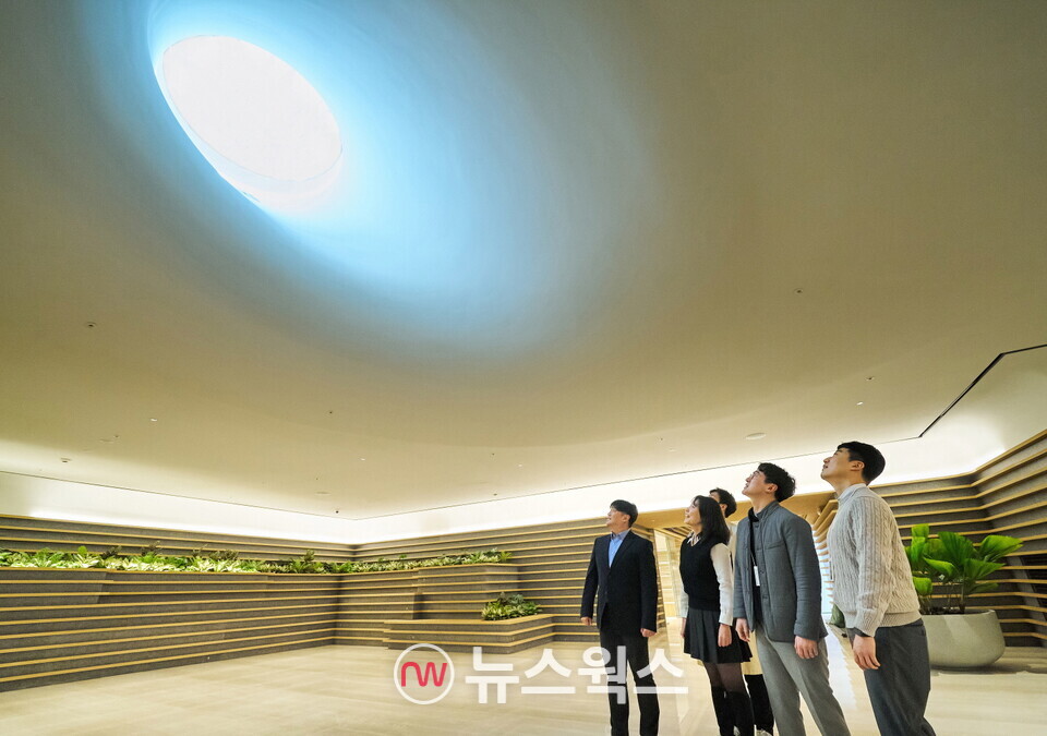 LG 직원들이 LG트윈타워 지하 1층에 새로 조성된 ‘틴들’에서 햇빛이 들어오는 천장을 바라보고 있다. (사진제공=LG)