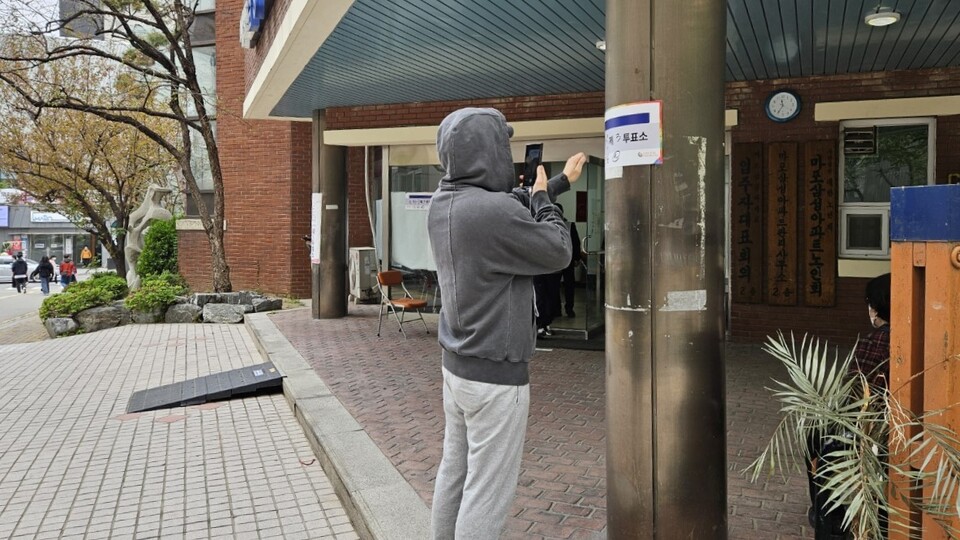 제22대 국회의원 선거 본투표일인 10일 오전 서울 마포구 도화동 제3투표소 앞에서 한 주민이 투표를 마치고 인증샷을 찍고 있다. (사진=이한익 기자)