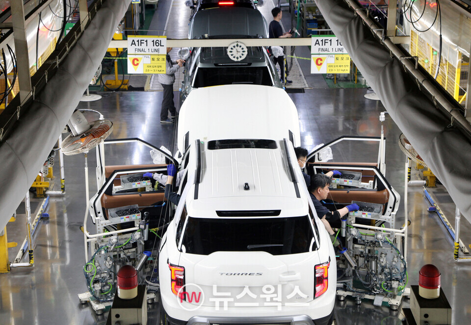 KG모빌리티 평택공장 조립 라인에서 작업자들이 토레스 문을 장착하고 있다. (사진제공=KG모빌리티)