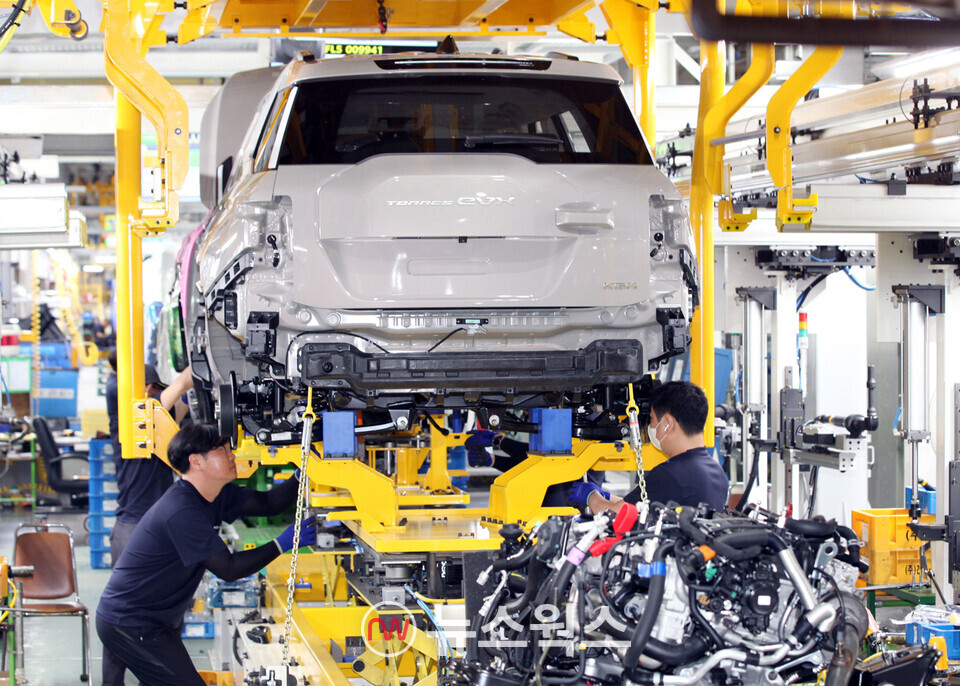KG모빌리티 평택공장 조립 라인에서 작업자들이 메리지 포인트에 맞춰 토레스 EVX 차체와 배터리를 장착하고 있다. (사진제공=KG모빌리티)