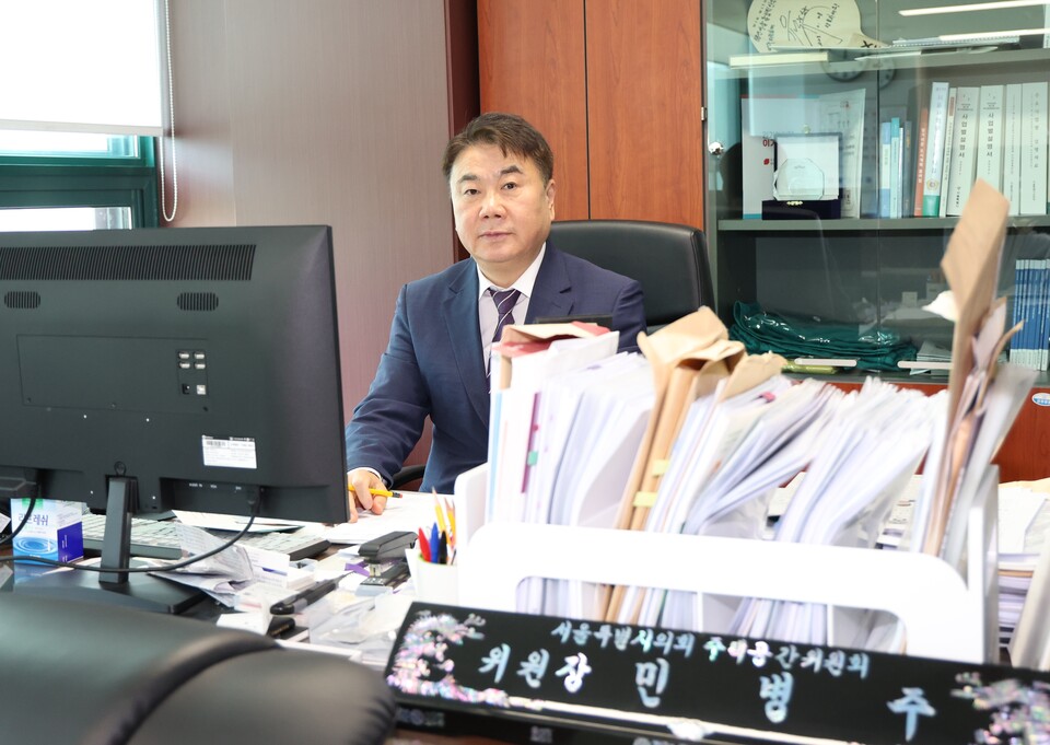 민병주 위원장이 25일 인터뷰를 하기 전 서류가 가득 쌓인 위원장석에 앉아 있다. (사진=서울시의회 출입기자단)