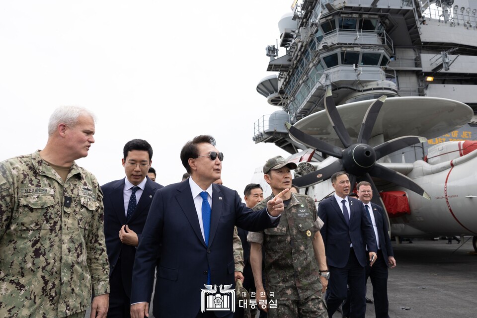 윤석열 대통령이 지난 25일 오후 부산 해군작전기지에 정박 중인 미국 항공모함 시어도어 루즈벨트 항공모함을 방문, 크리스토퍼 알렉산더 9항모강습단장과 양용모 해군참모총장과 함께 루즈벨트함 비행갑판을 시찰하고 있다. (출처=대통령실 홈페이지)