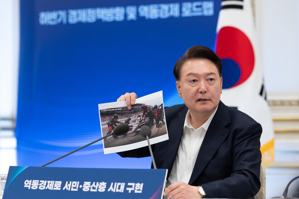 윤석열 대통령이 3일 서울 청와대 영빈관에서 열린 '역동경제로 서민·중산층 시대 구현' 하반기 경제정책방향 및 역동경제 로드맵 행사에서 F1 경기 도중 피트스탑 장면을 찍은 사진을 들고 발언을 하고 있다. (사진제공=대통령실)