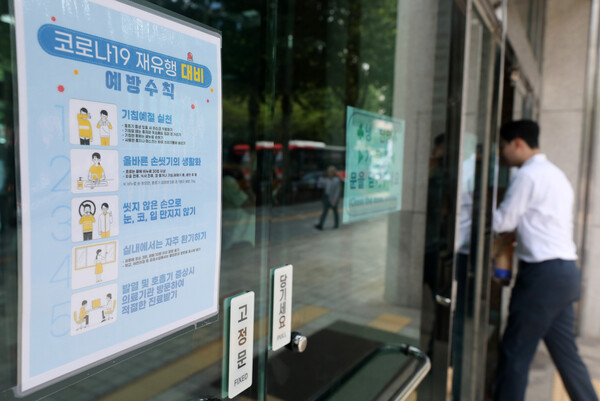 13일 서울시내 한 빌딩 입구에 코로나19재유행 예방수칙 안내문이 붙여있다. (사진=뉴스1)