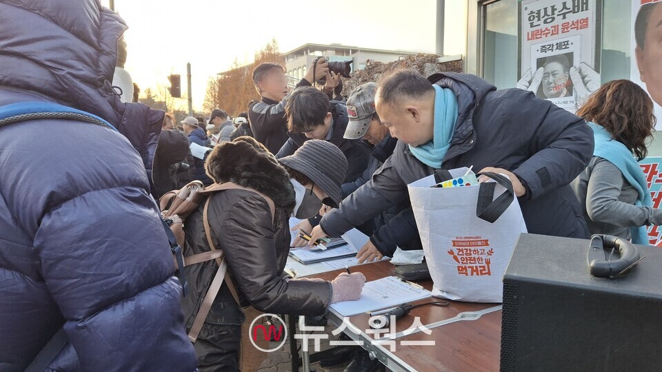 윤석열 대통령 탄핵을 촉구하는 시민들이 서명 운동에 참여하고 있다. (사진=강석호 기자)