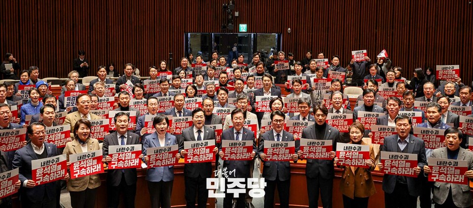 이재명(앞줄 가운데) 민주당 대표를 비롯한 민주당 의원들이 지난 23일 국회 예결위회의장에서 열린 '민주당 의원총회'에서 손팻말을 들고 구호를 외치고 있다. (사진제공=민주당)
