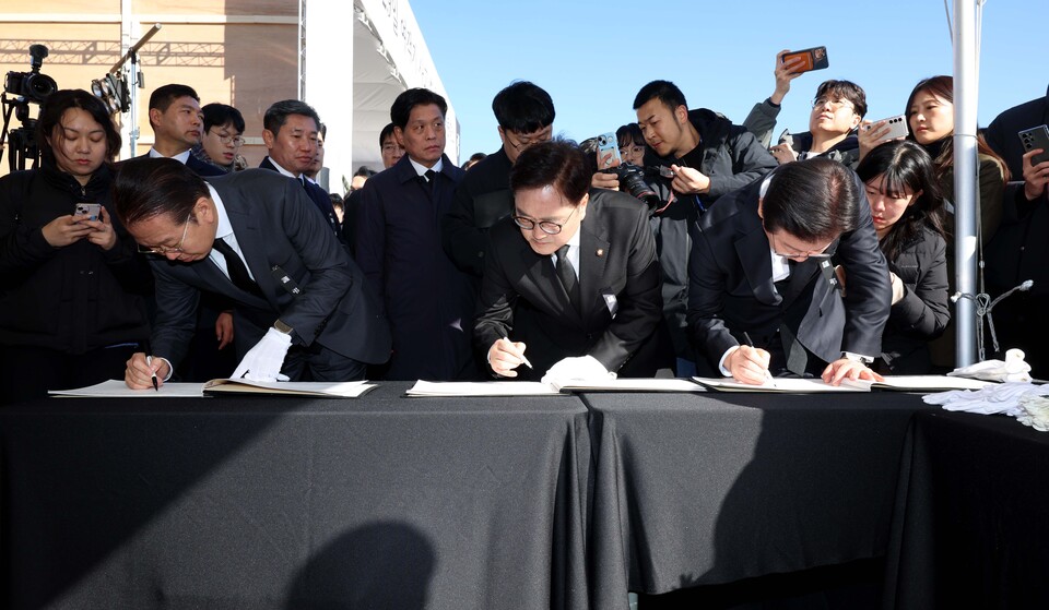 우원식(가운데) 국회의장과 권영세(왼쪽) 국민의힘 비상대책위원장, 이재명 더불어민주당 대표가 31일 국회에 마련된 '제주항공 여객기 사고 국회분향소'에서 헌화한 뒤 방명록을 작성하고 있다. (사진=뉴스1)
