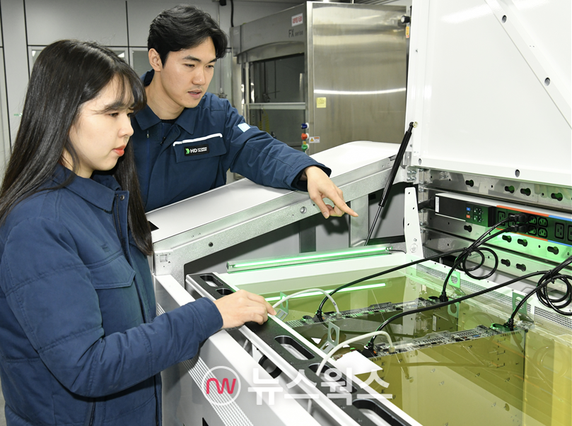 HD현대오일뱅크 직원들이 액침냉각설비에 담긴 냉각유와 서버를 테스트하고 있다. (사진제공=HD현대오일뱅크)