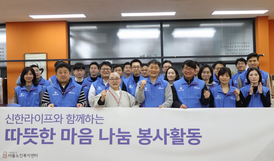 이영종(앞줄 오른쪽에서 세번째) 신한라이프 대표를 비롯한 임직원들이 25일 종로구 서울노인복지센터에서 배식 봉사 전 지웅 스님과 기념 촬영을 하고 있다. (사진제공=신한라이프)