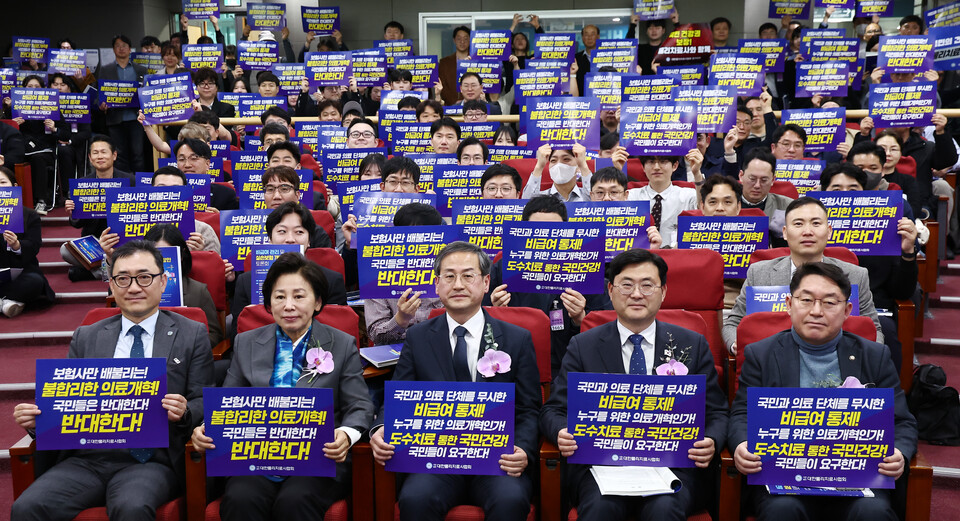 이정문(오른쪽 두번째), 남인순(왼쪽 두번째) 더불어민주당 의원을 비롯한 참석자들이 14일 서울 여의도 국회의원회관에서 열린 '비급관리 및 실손보험 개혁 방안 토론회'에서 의료개혁을 반대하는 손피켓을 들고 기념촬영을 하고 있다.(사진=뉴스1)