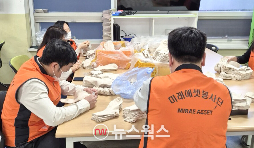 미래에셋생명 임직원 봉사단이 24일 서울 우리마포종합복지관에서 장애인들의 직업재활 활동을 돕는 양말 포장 작업을 하고 있다. (사진제공=미래에셋생명)