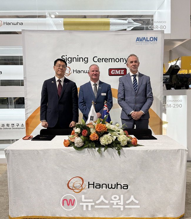 박성균 한화시스템 DE1 사업단장(왼쪽)과 딘 미치(가운데) 한화에어로스페이스 호주법인장 대행, 스테픈 밀러 GME CEO가 26일 호주 질롱에서 호주 국방부 방위군의 차세대 군 통신 개발사업인 ‘LAND 4140’에 참여하기 위한 협력 합의서를 교환하고 있다. (사진제공=한화시스템)