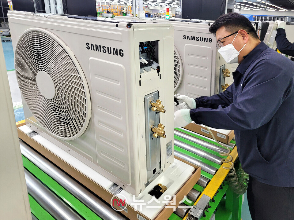 삼성전자 에어컨 생산라인에서 작업자가 에어컨 실외기를 조립하고 있다. (사진제공=삼성전자)