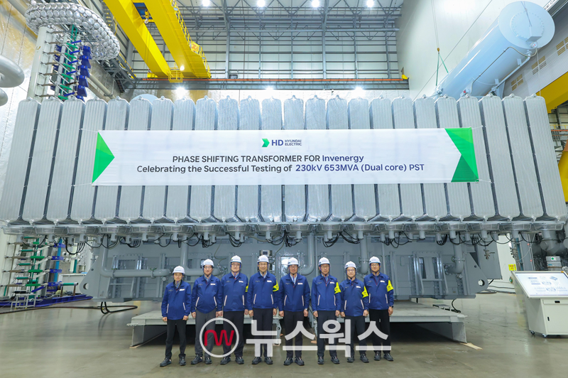 HD현대일렉트릭 임직원들이 최근 HD현대일렉트릭 변압기 공장에서 230킬로볼트(kV)급 653MVA 위상조정변압기의 최종 승인시험 이후 기념촬영을 하고 있다.(사진제공=HD현대)