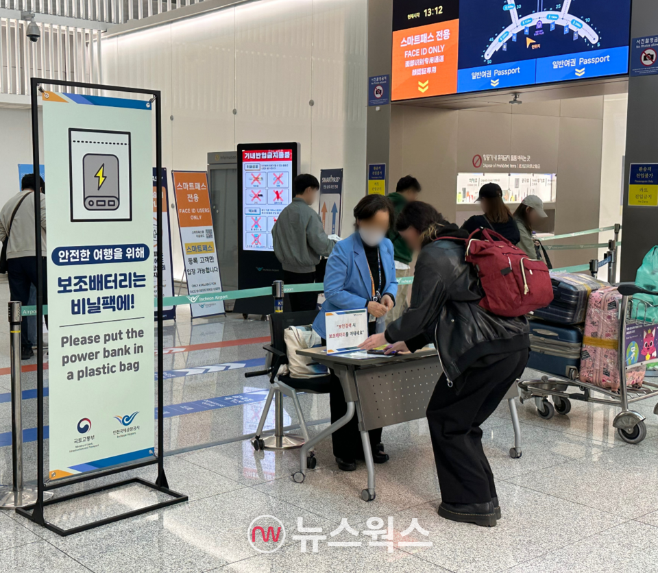 22일 오후 인천국제공항 제1터미널 출국장 입구에 마련된 보조배터리 기내 반입 안내 데스크에서 자원봉사자가 승객에게 비닐봉투를 제공하고 있다. (사진=정현준 기자) 
