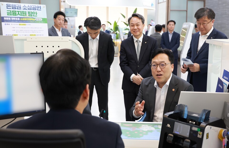 8일 서울시 중구 신한은행 본점 영업부에서 ‘은행권 소상공인 금융지원 현장 간담회’를 개최했다. 이날 간담회에는 김병환 금융위원장과 진옥동 신한금융 회장 등이 참석한 가운데 김병환 금융위원장이 직원의 설명을 경청하고 있다. (사진제공=신한은행)