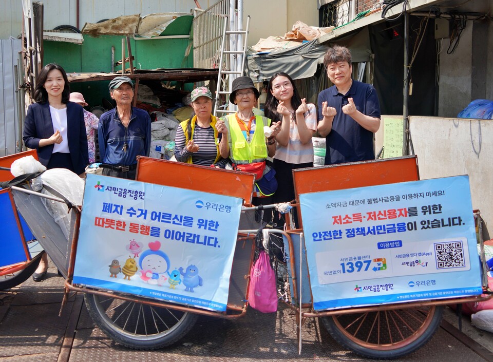 하현신(왼쪽) 우리은행 상생금융부장이 신승주 서민금융진흥원 홍보협력실장과 전달식 이후 어르신들과 함께 기념 촬영을 하고 있다. (사진제공=우리은행)
