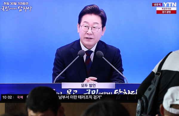 3일 오전 서울역 대합실에서 시민들이 이재명 대통령 '취임 한달' 기자회견 생중계 영상을 시청하고 있다. (사진=뉴스1)