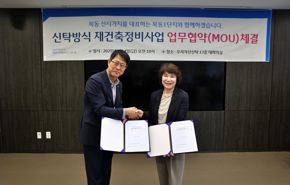 김범석(왼쪽) 우리자산신탁 대표와 정현숙 목동1단지 재건축준비위원장이 재건축 협력을 다짐하며 악수를 하고 있다. (사진제공=우리은행)