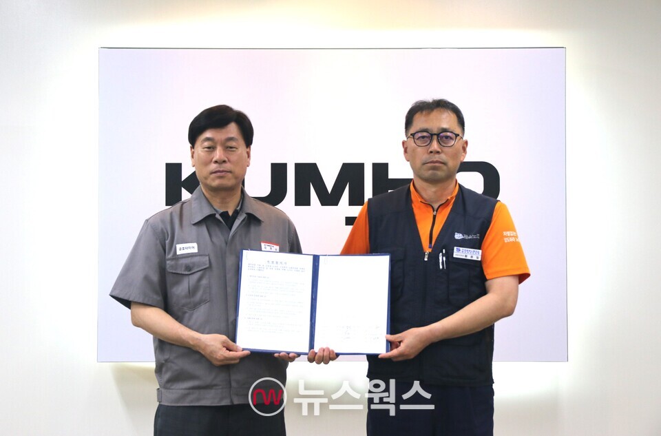 김명선(왼쪽) 금호타이어 생산기술총괄 부사장과 황용필 금호타이어지회 대표 지회장이 노사 특별합의문을 들고 사진을 찍고 있다. (사진제공=금호타이어)