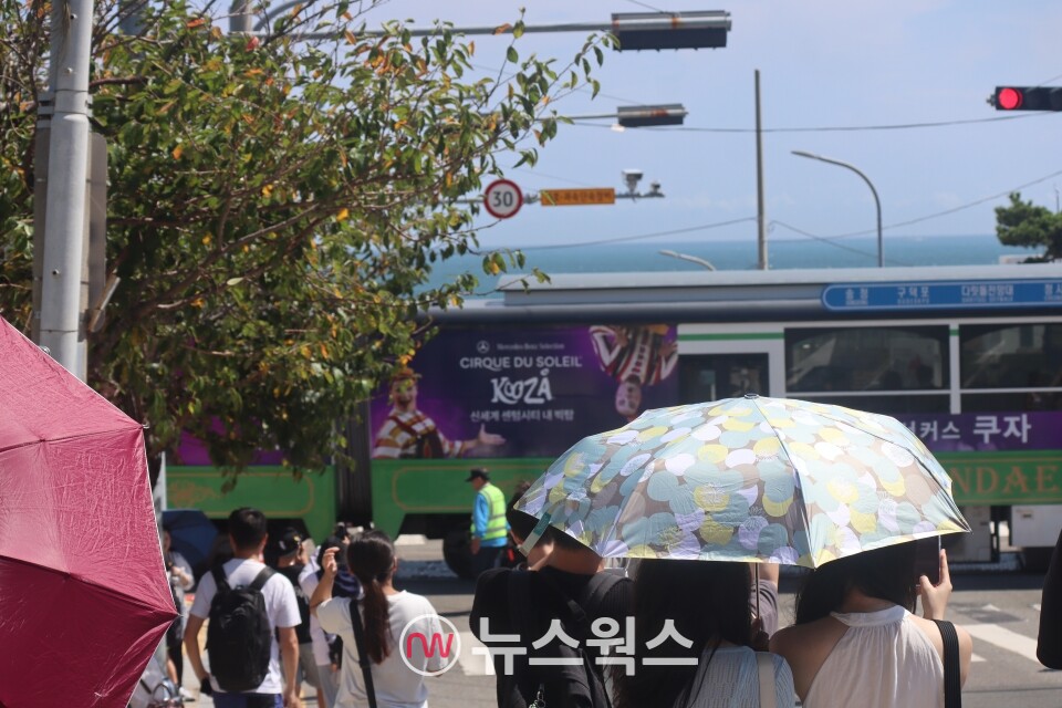 부산 청사포항 해운대블루라인파크 앞에서 시민들이 양산을 쓴 채 기념사진을 촬영하고 있다. (사진=박성민 기자)
