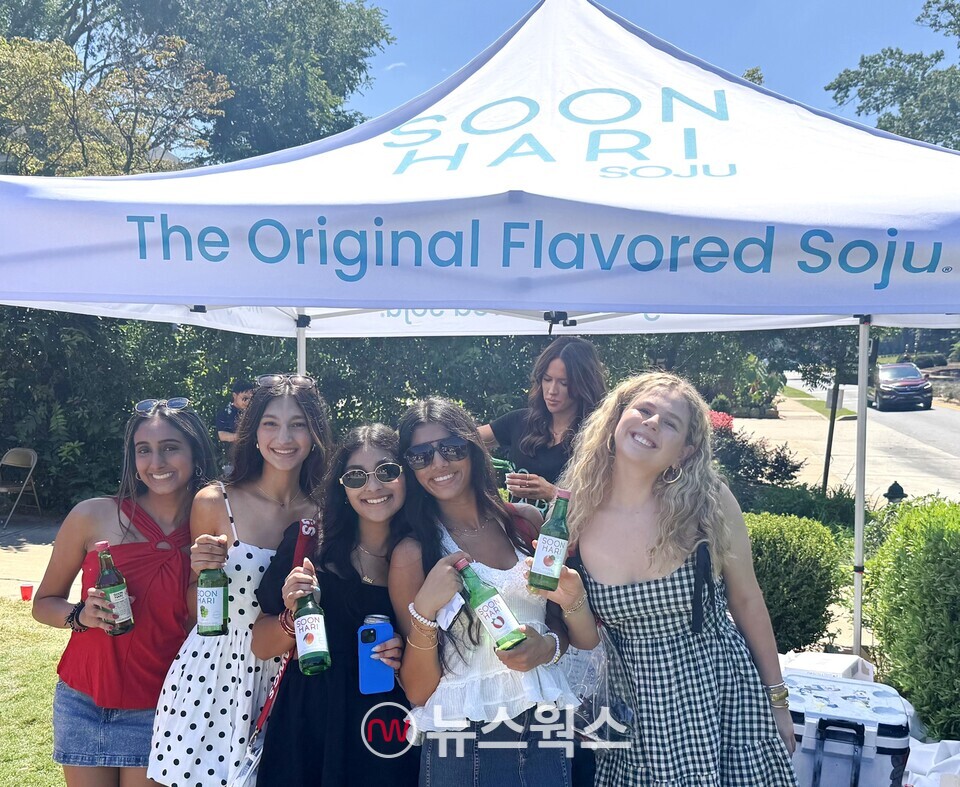 롯데칠성음료가 미국에서 과일소주 순하리를 알리는 마케팅 활동을 펼친 가운데 소비자들이 순하리를 들고 기념 촬영을 하고 있다. (사진제공=롯데칠성음료)