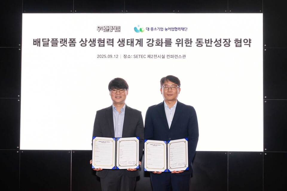 김중현(왼쪽)우아한형제들 가치경영실장이 지난 12일 서울 강남구 SETEC에서 변태섭 대·중소기업·농어업협력재단 사무총장과 배달플랫폼 상생협력 생태계 강화를 위한 동반성장 협약 체결을 기념해 사진을 촬영하고 있다. (사진제공=배달의민족)