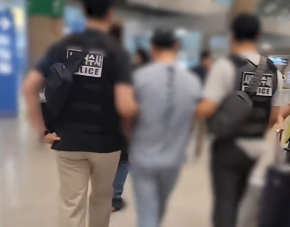 경찰이 인천공항에서 KT 무단 소액결제 해킹 사건 용의자를 정통망법 위반 침해 혐의로 체포해 압송하고 있다. (출처=경기남부경찰청)
