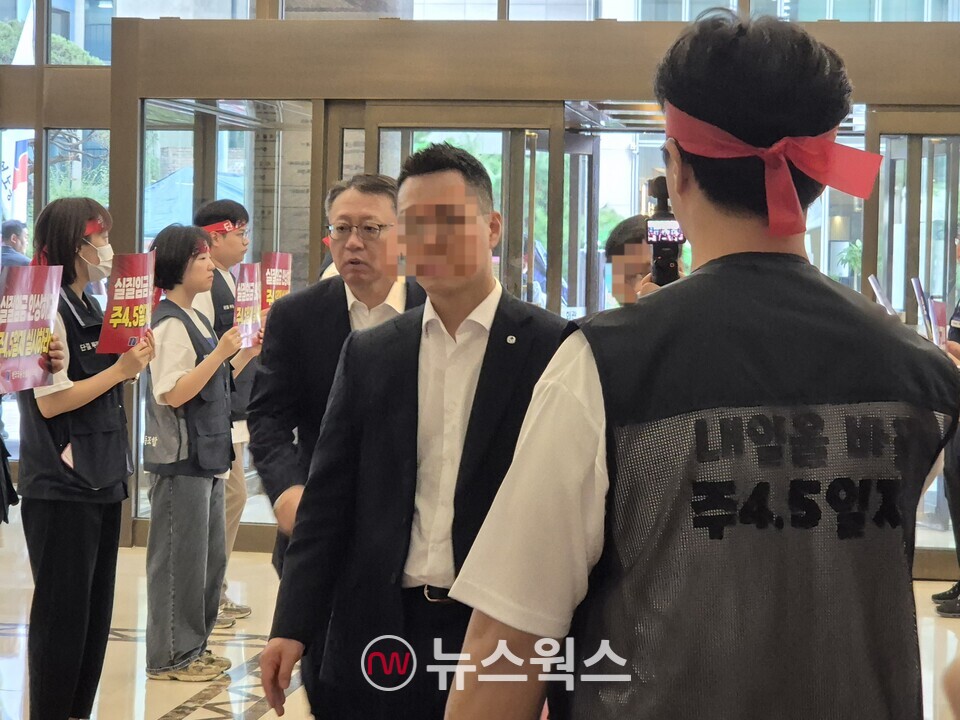 정진완 우리은행장이 굳은 표정으로 시위 현장을 벗어나고 있다. (사진=정희진 기자)