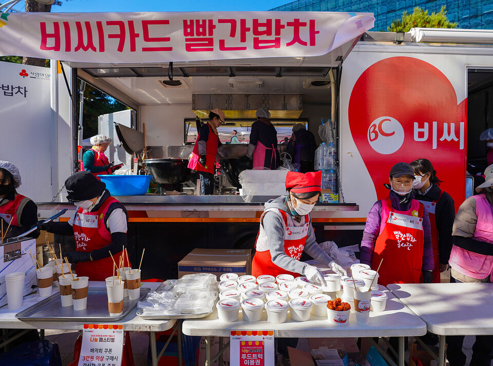 BC카드 빨간밥차 관계자들이 지난 14일 서울 중구청에서 진행한 '따뜻한 겨울나기' 나눔 바자회에서 무료급식 지원을 하고 있다. (사진제공=BC카드)