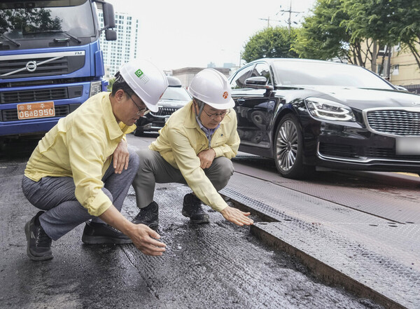 강기정 광주시장이 지난 7월 21일 서구 상무중학교 인근 도시철도 2호선 1단계 공사 현장에서 복공판과 도로면 단차 해소를 위한 주행차로 덧씌우기(포장) 공사 진행 과정을 살펴보고 있다. (사진제공=광주시)