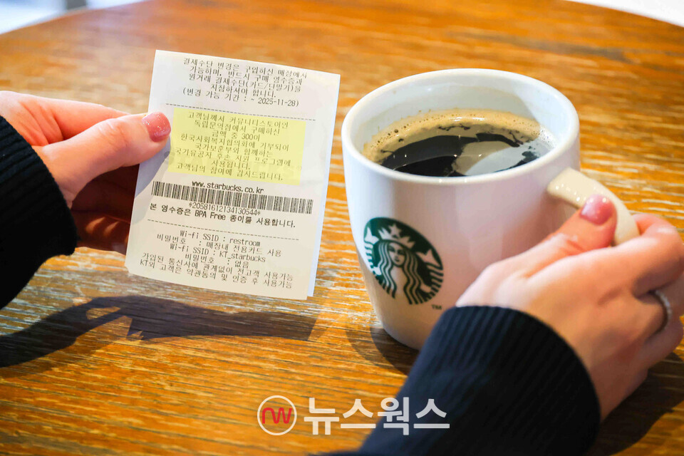 스타벅스를 찾은 고객이 독립유공자 후손 주거지원금 전달 문구가 쓰인 영수증을 확인하고 있다. (사진제공=스타벅스코리아)