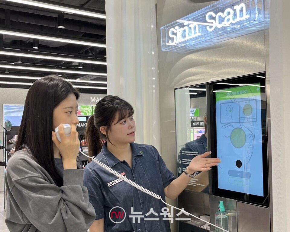올리브영 합정메세나폴리스점에 도입된 '스킨스캔' 기기 앞에서 고객이 피부 측정을 하고 있다. (사진제공=CJ올리브영)