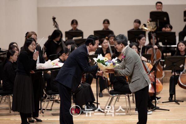 꿈쟁이오케스트라 정기연주회에 참석한 후원자에게 꽃다발을 전달하고 있다. (사진제공=수원시)