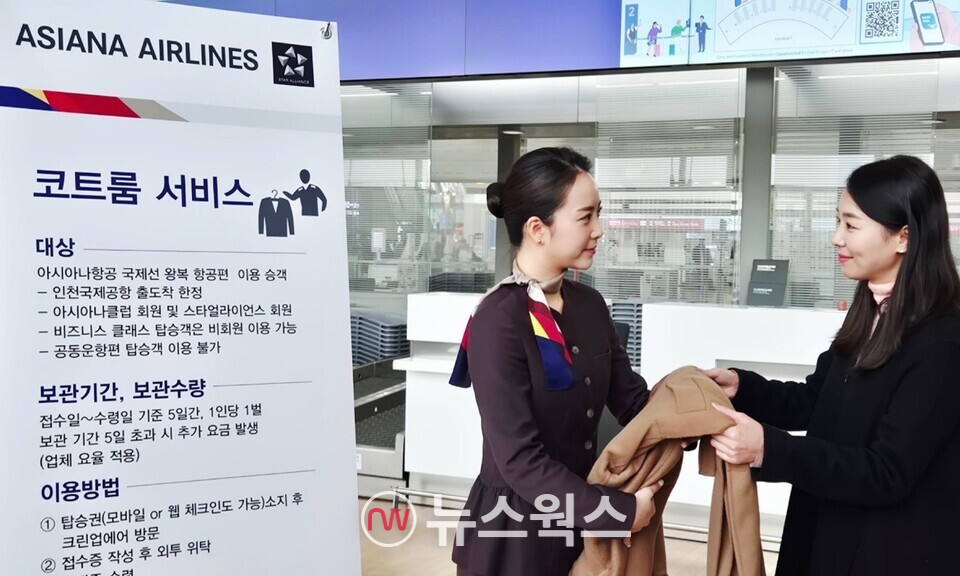 아시아나항공 직원이 승객의 외투를 받고 있다. (사진제공=아시아나항공)